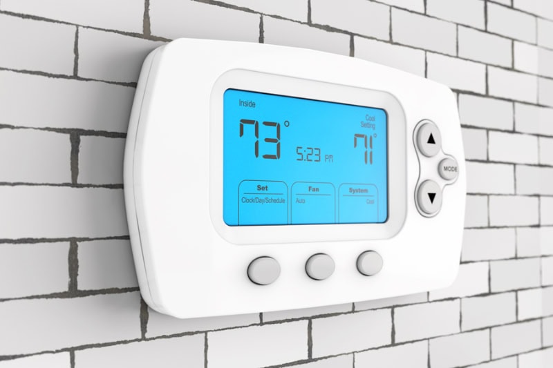 Winterizing Your HVAC Equipment: Cozy Tips From Pyramid Heating and Cooling. Modern Programming Thermostat in front of Brick Wall.