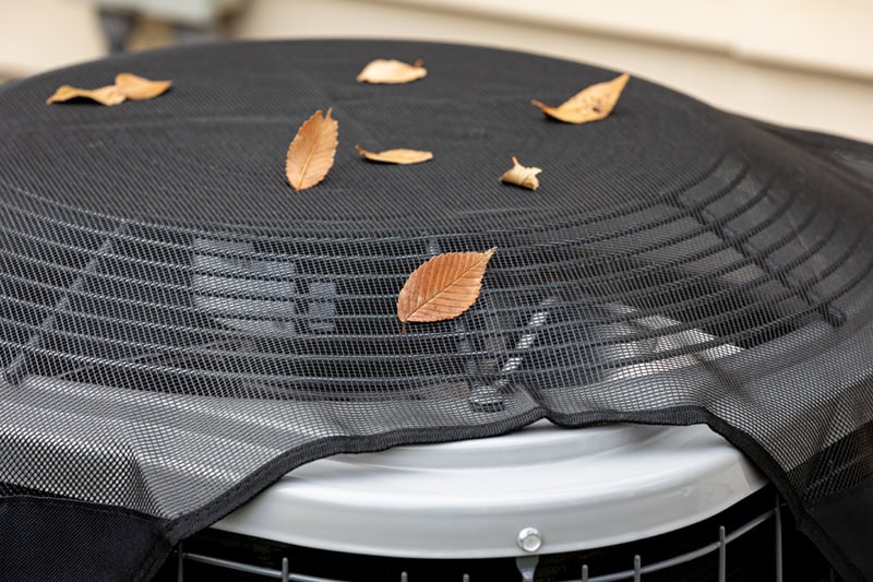 Fall HVAC Maintenance Checklist: Keep Your Home Cozy and Efficient. An air conditioning unit with leaves.